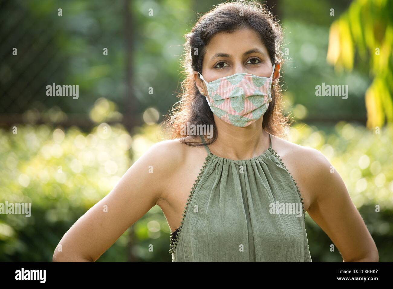 Donna con maschera protettiva al parco Foto Stock