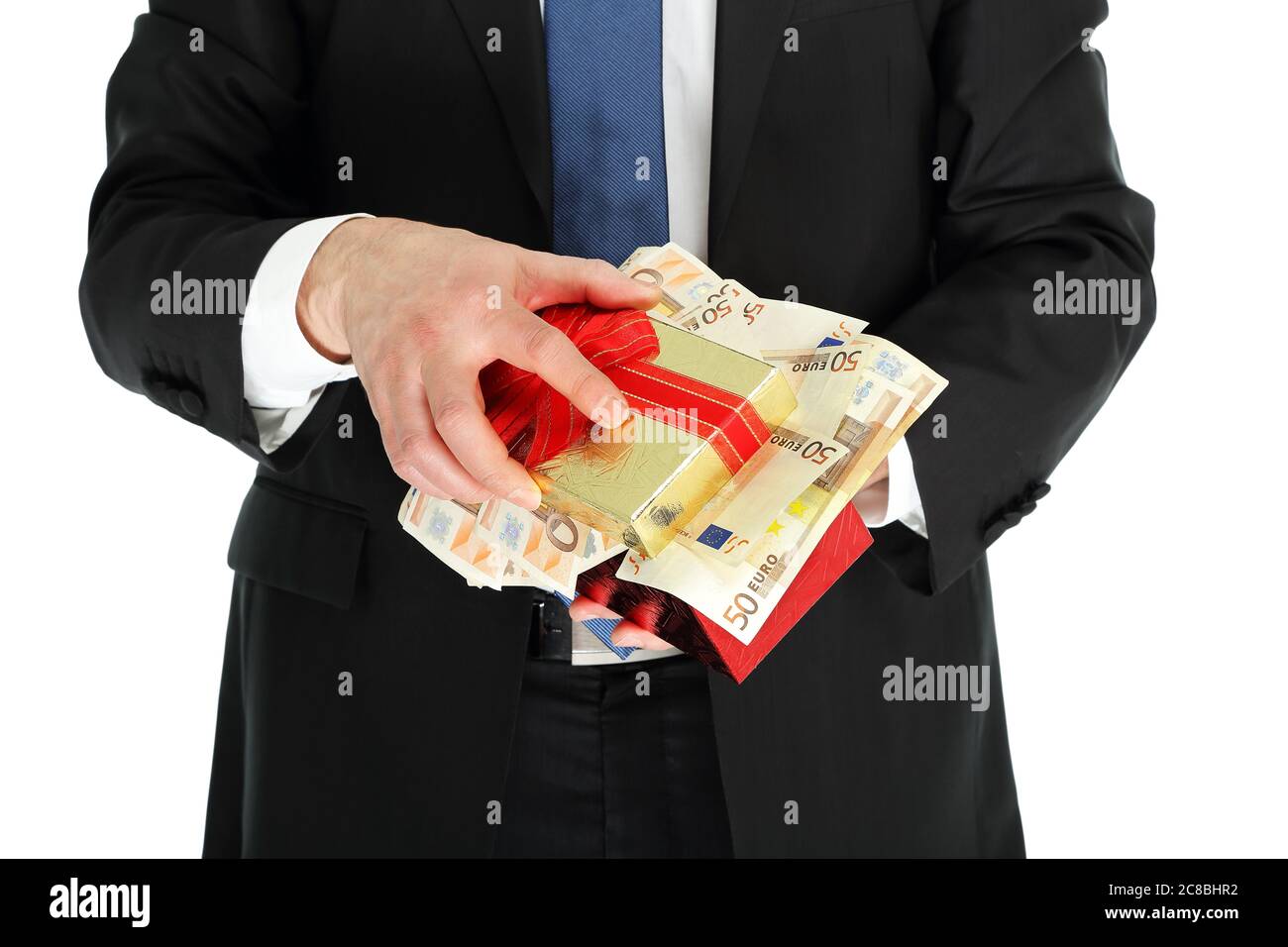 uomo in abito che tiene una scatola di regalo piena di soldi Foto Stock