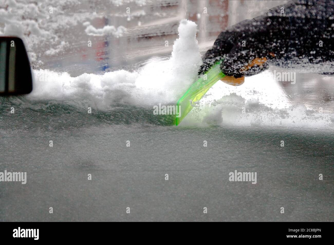 Pulire il parabrezza di un'auto da neve e ghiaccio. Foto Stock