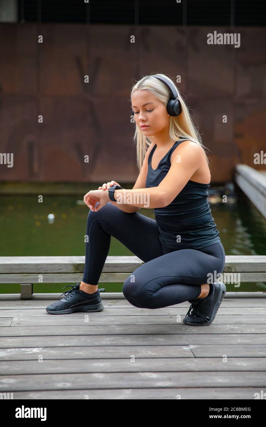 Bella donna fitness runner utilizzando smart guardare telefono Foto Stock