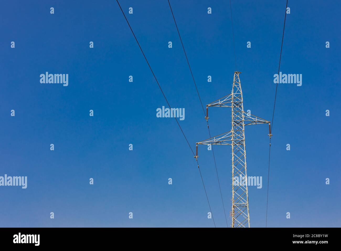 Potenza di trasmissione dell'elettricità. Torre ad alta tensione con fili su sfondo sfocato. Energia industriale Foto Stock