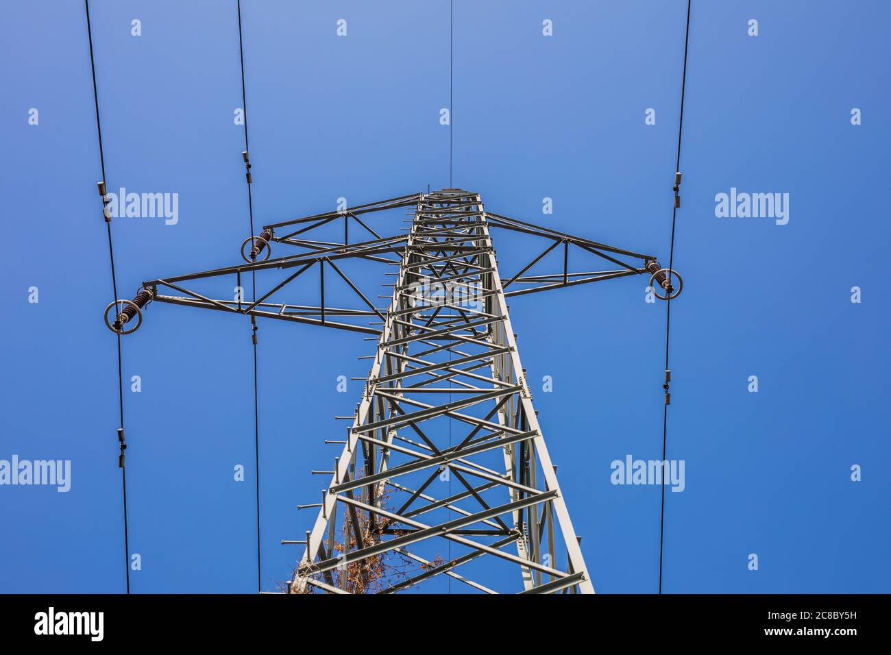 Potenza di trasmissione dell'elettricità. Torre ad alta tensione con fili su sfondo sfocato. Energia industriale Foto Stock