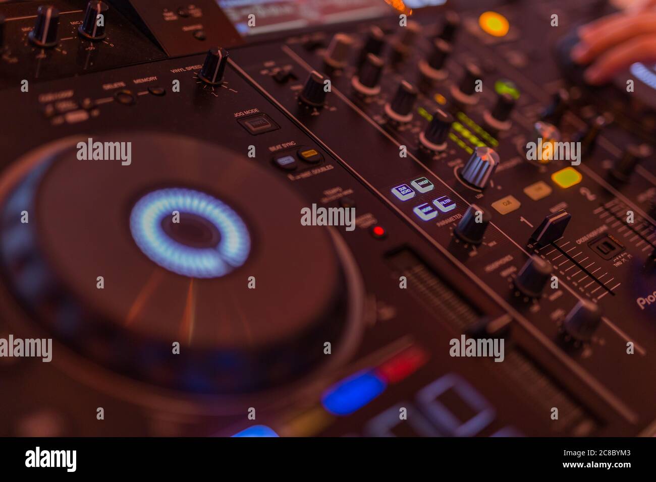 DJ che gira, mixando e graffiando in un night club. DJ che suona musica al mixer. Primo piano, festa. Foto Stock