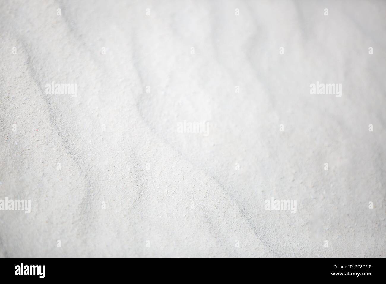 Tessitura ondulata di sabbie bianche soffiate nel vento. Sfondo di sabbia bianca natura texture Foto Stock