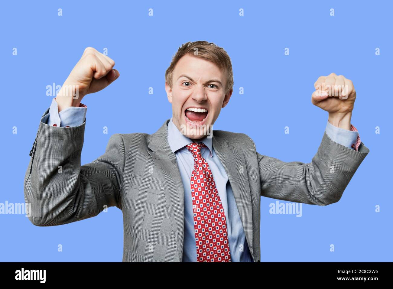 Festeggiando l'uomo d'affari che fa il pugno all'aria in festa Foto Stock