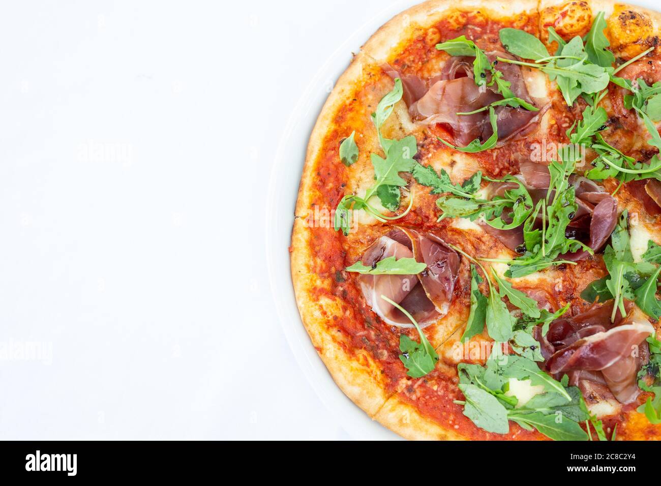 Pizza Margarita adornata semplicemente nei colori della bandiera italiana verde dal basilico, bianco dalla mozzarella, rosso dal sugo di pomodoro, isolato su bianco Foto Stock