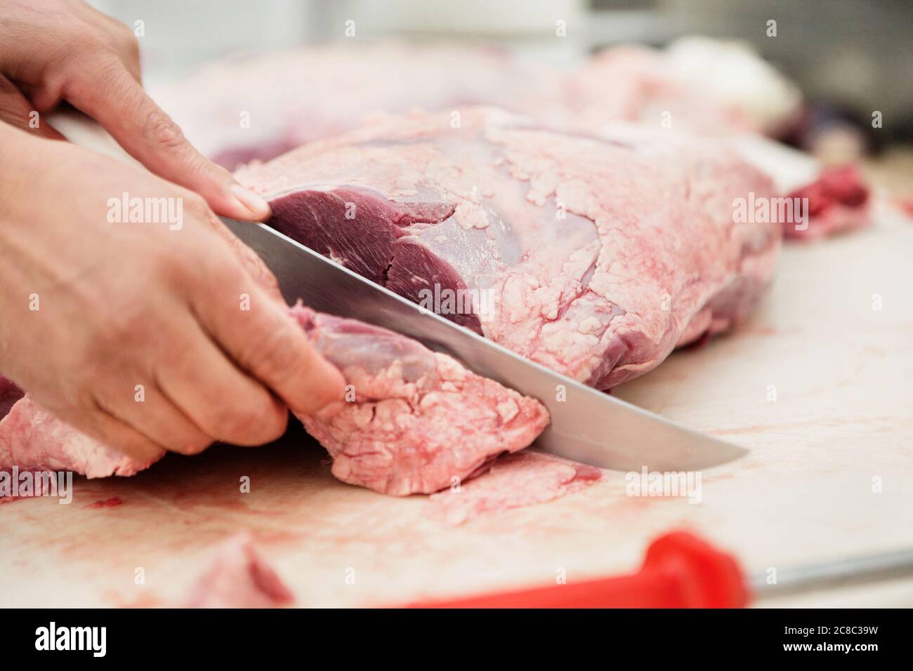 Primo piano di macellaio speleologia pezzo di carne in macellai Foto Stock