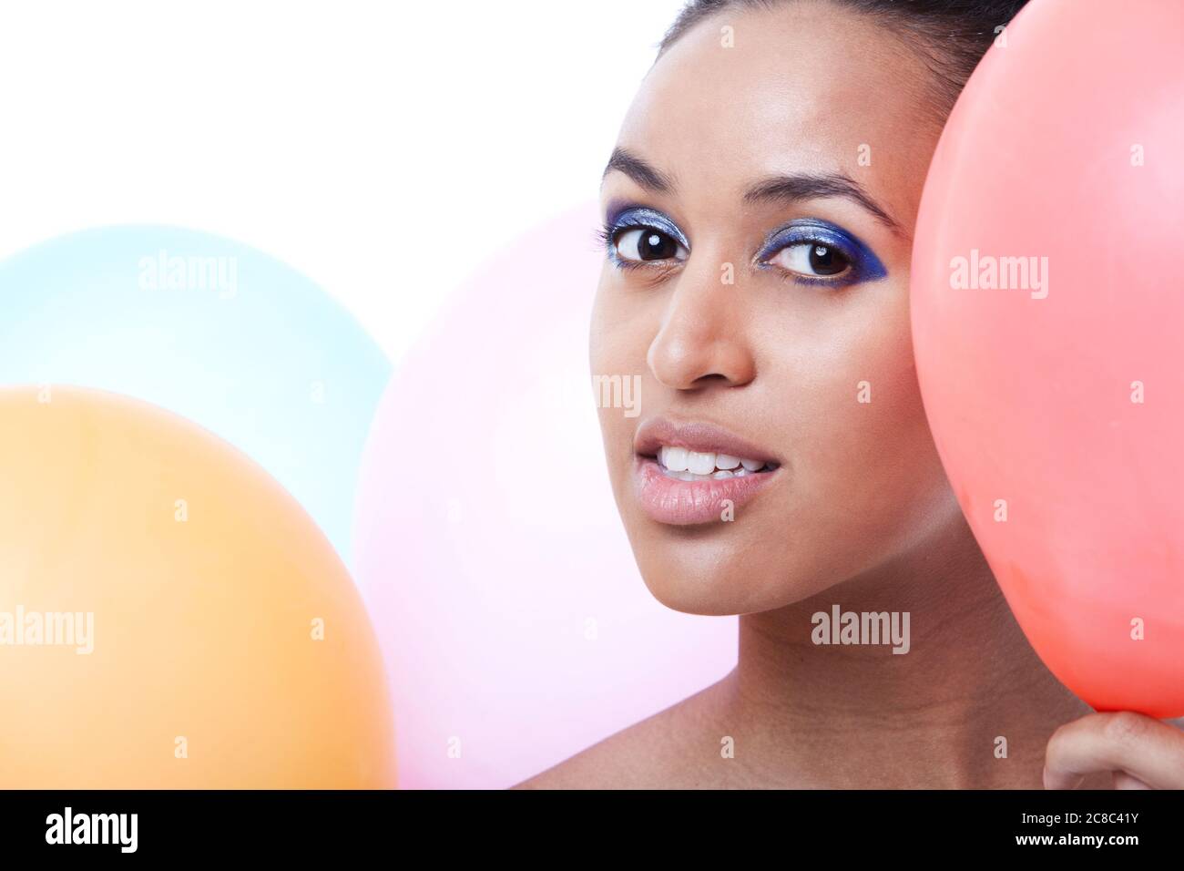 Femmina nera che si nasconde dietro i palloncini Foto Stock