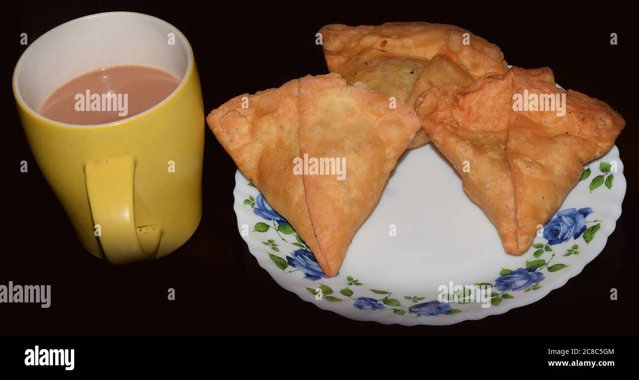 Spuntini Indiani Samosa con te' caldo Foto Stock