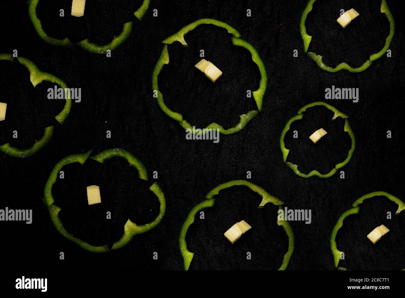 taglio di peperoni verdi in forma rotonda e cubetti di formaggio. Foto Stock