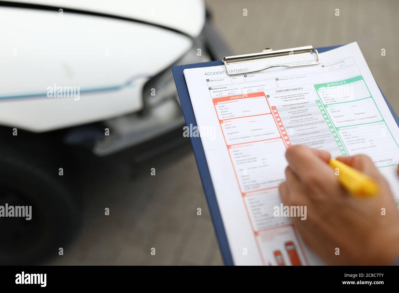 L'agente redige un evento assicurato dopo un incidente d'auto. Foto Stock
