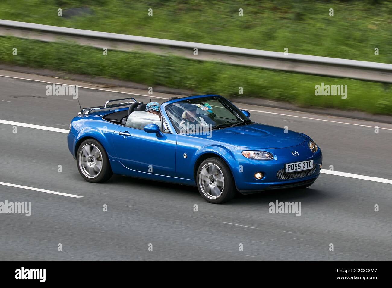 Un 2006 Mazda MX-5 Blue Car Roadster benzina guida sulla M6autostrada vicino Preston a Lancashire, Regno Unito Foto Stock