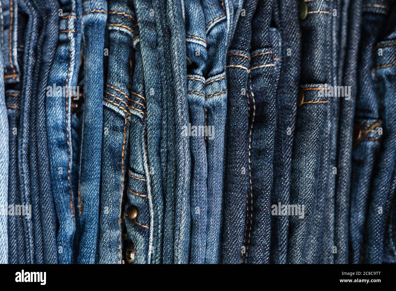 Pila di jeans blu di diverse sfumature. Jeans sfondo. Primo piano. Messa a fuoco morbida Foto Stock