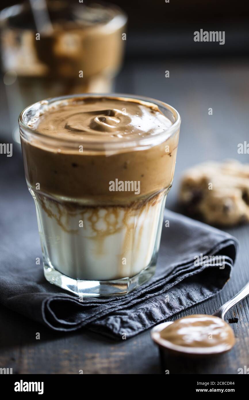 Caffè montato servito in un bicchiere con biscotti al burro di arachidi Foto Stock