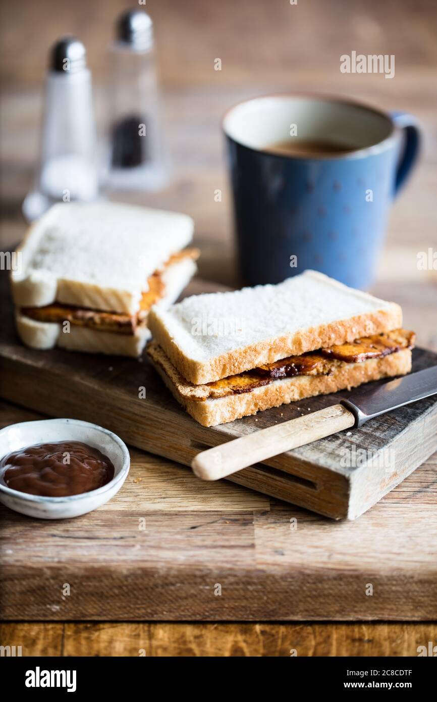 Tofu panino stile pancetta vegana con tazza di tè Foto Stock