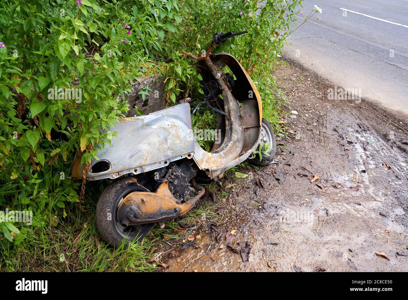 Un ciclomotore bruciato abbandonato a lato di una strada, Cardiff, Galles del Sud Foto Stock Un ciclomotore bruciato abbandonato a lato di una strada, Cardiff, Galles del Sud Foto Stock