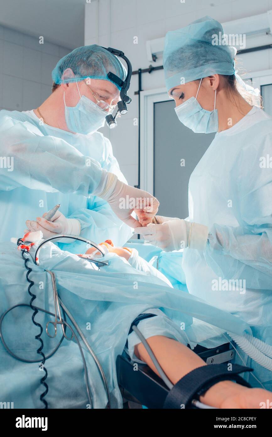 Un altro intervento chirurgico. Team medico chirurgico che opera in una sala chirurgica del chirurgo maturo ospedale che conduce un occup professionale di professione di operazione Foto Stock