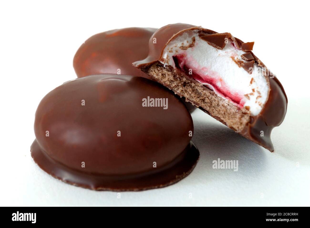 Dolce pasticceria e dolcetti marshmallow concetto di delizie con marshmallow rivestito in cioccolato al latte isolato su fondo bianco con una padella da taglio Foto Stock