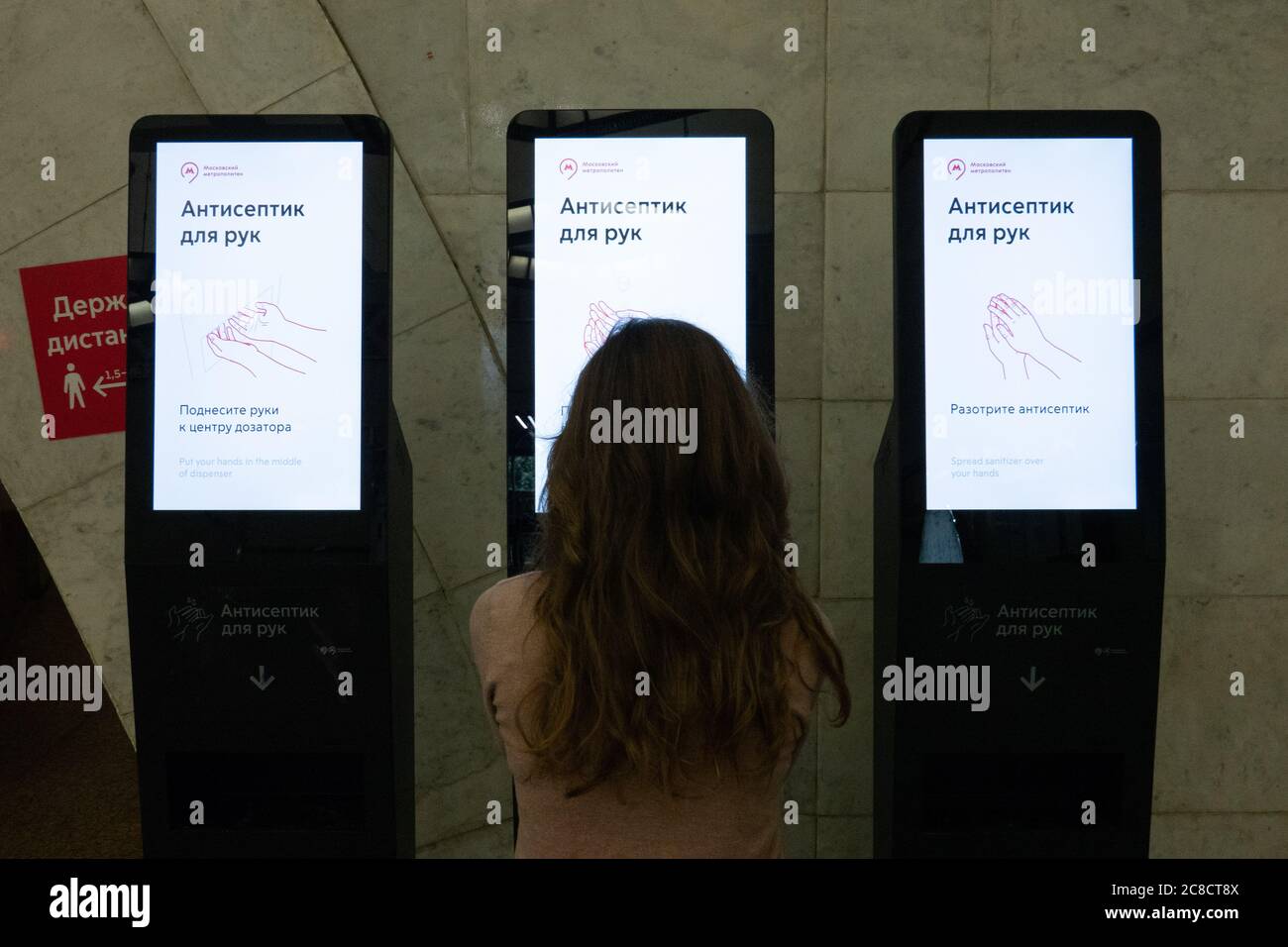 Donna che le tratta le mani con antisettico all'interno della metropolitana di Mosca Foto Stock