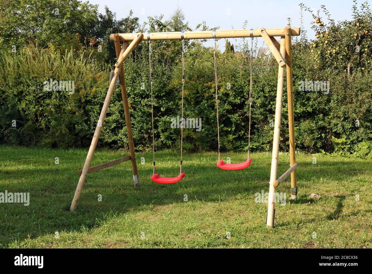 Altalena per bambini fatta di tronchi e corde e installato nel cortile di una casa rurale Foto Stock