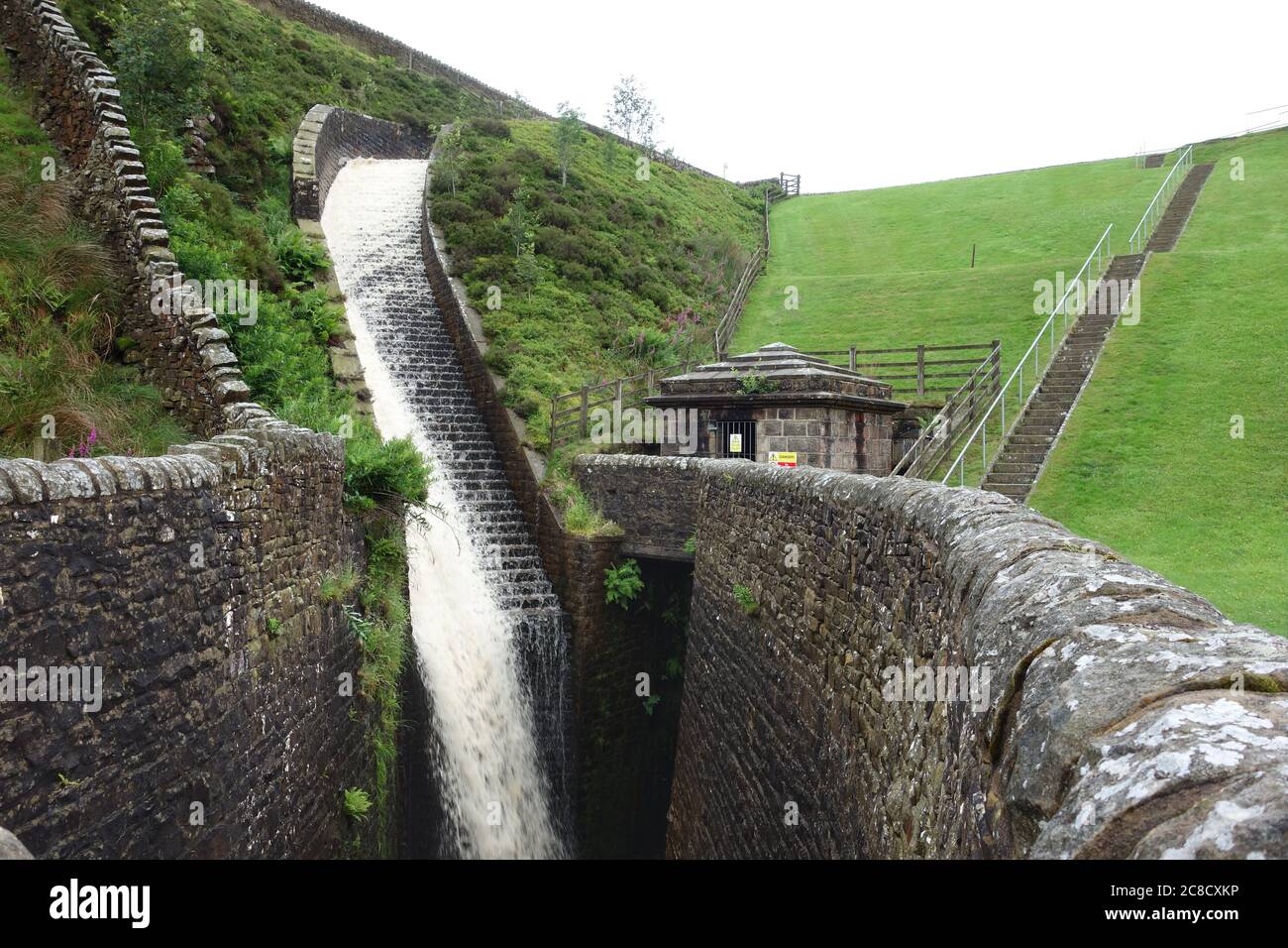 La cascata di deflusso sul lato della diga di Upper Ogden Reservoir in Ogden Clough su Pendle Hill vicino al villaggio di Barley, Lancashire, Inghilterra, Regno Unito. Foto Stock