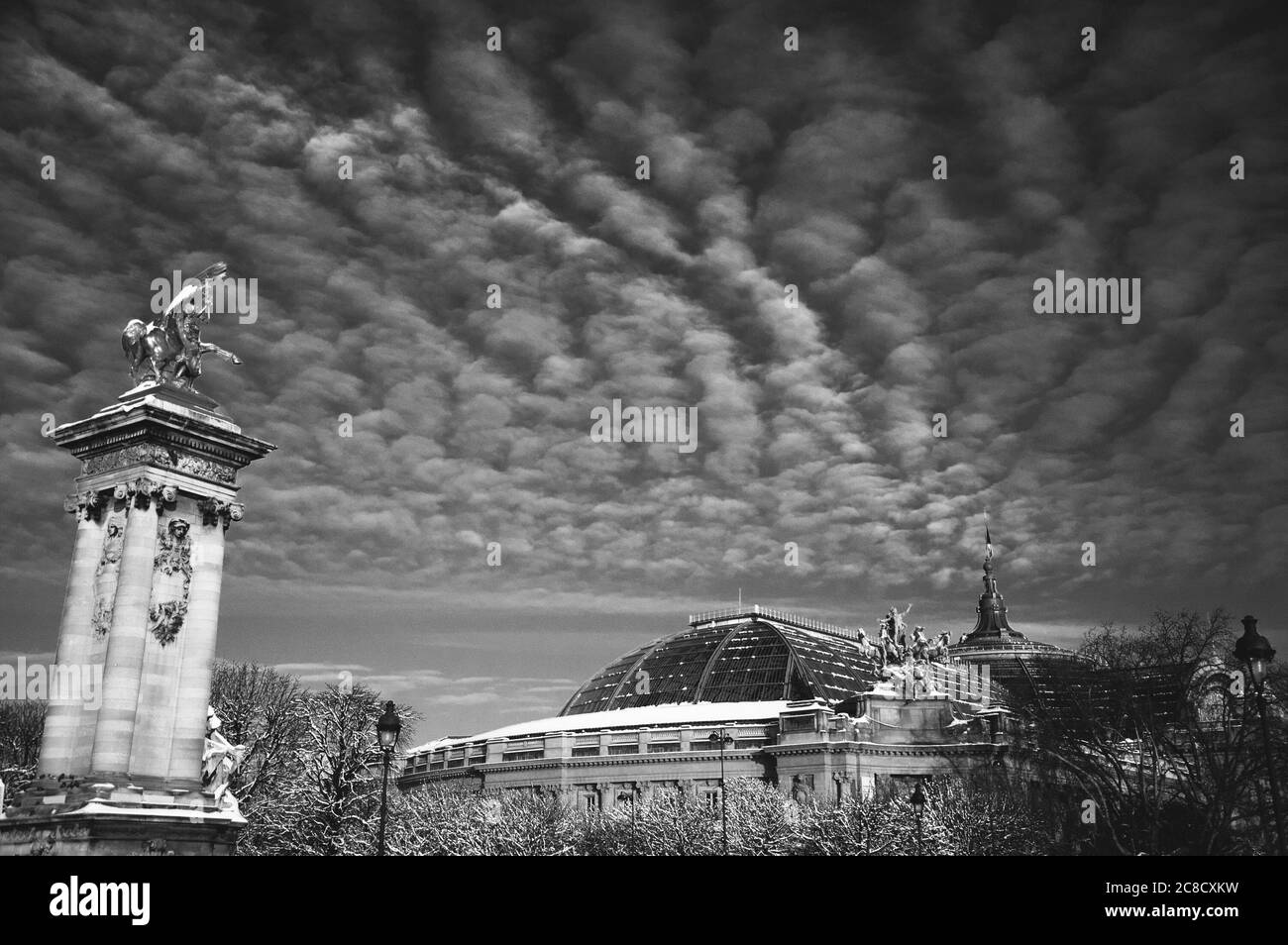 Parigi sotto la neve. Vista del Grand Palais dal Ponte Alexandre III. Bellissimo paesaggio nuvoloso. Foto storica in bianco nero Foto Stock