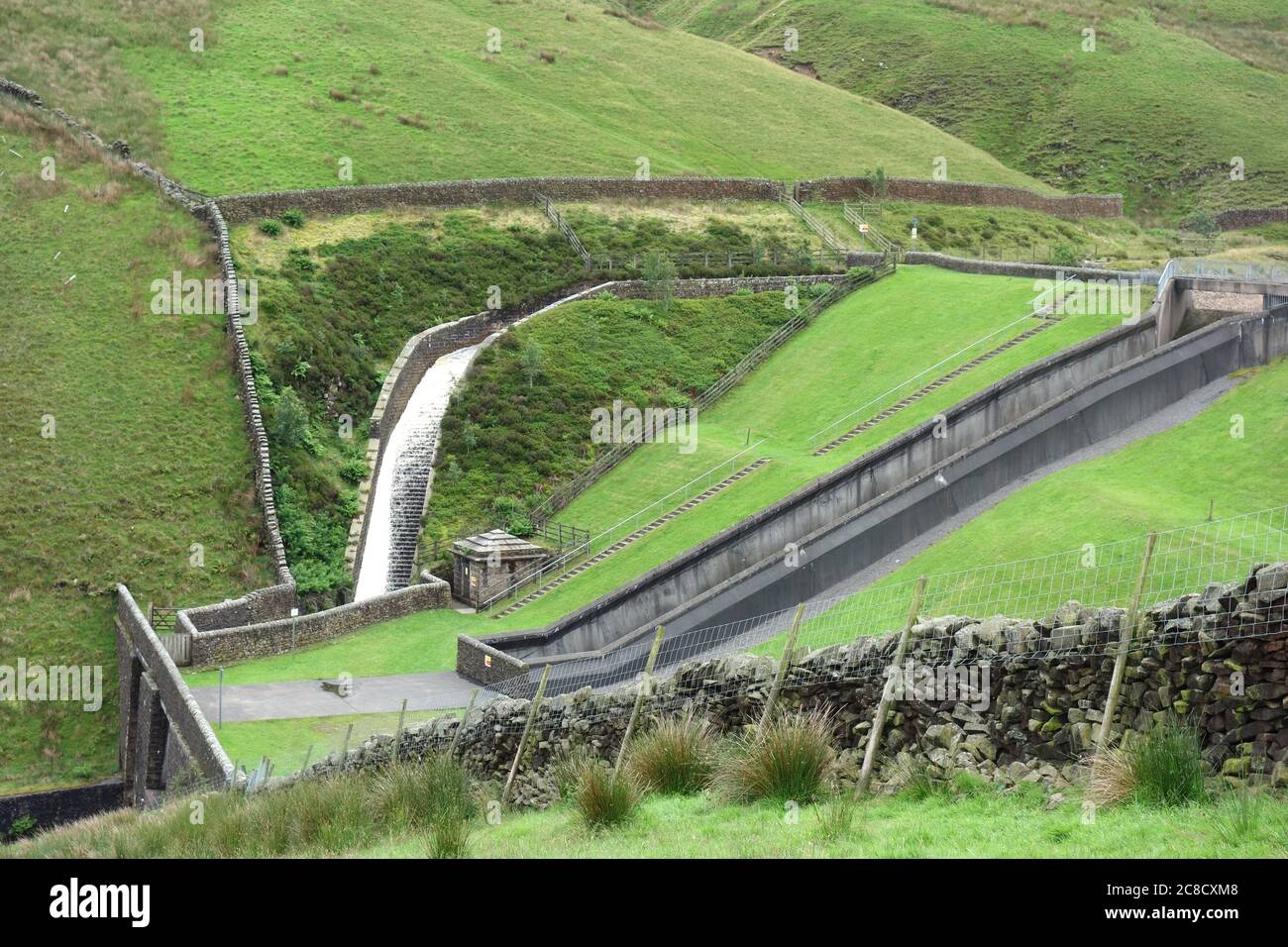 La cascata di deflusso sul lato della diga di Upper Ogden Reservoir in Ogden Clough su Pendle Hill vicino al villaggio di Barley, Lancashire, Inghilterra, Regno Unito. Foto Stock