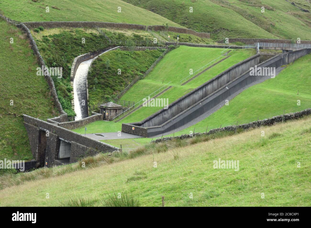 La cascata di deflusso sul lato della diga di Upper Ogden Reservoir in Ogden Clough su Pendle Hill vicino al villaggio di Barley, Lancashire, Inghilterra, Regno Unito. Foto Stock