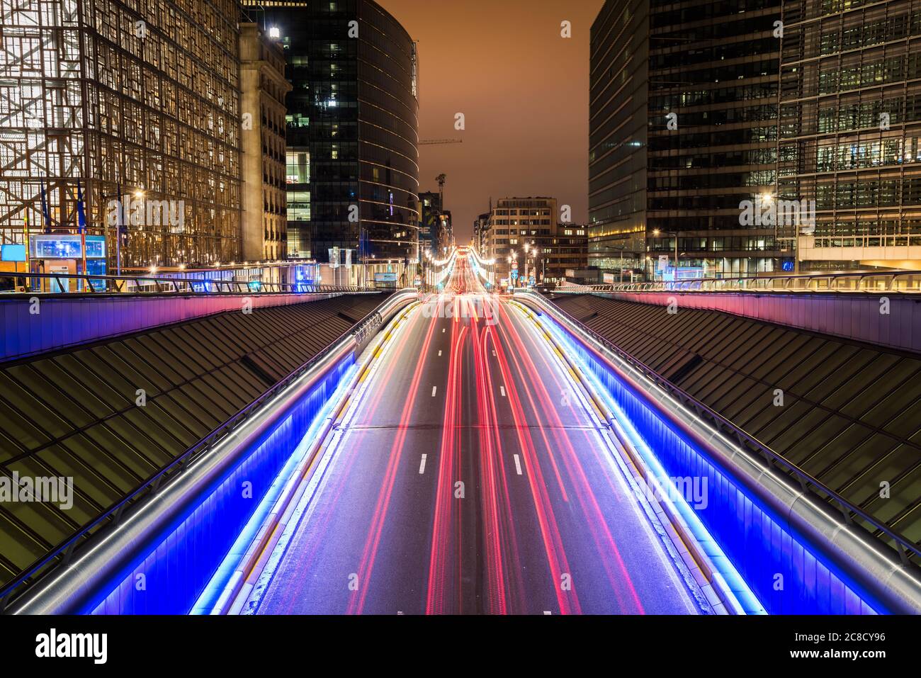 Sentieri leggeri su una strada che attraversa il quartiere europeo di Bruxelles, in Belgio, di notte. Esposizione lunga. Foto Stock