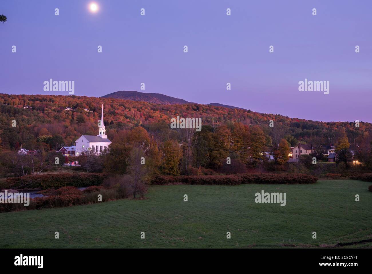 Villaggio di montagna con una tradizionale chiesa bianca in Vermont al tramonto in autunno. Splendido fogliame autunnale. Foto Stock