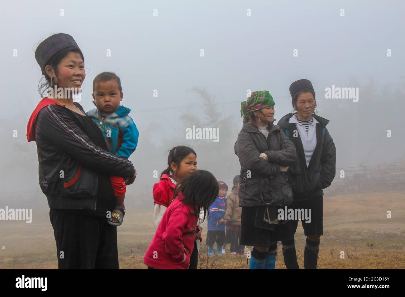 Sapa, Vietnam - 16 gennaio 2014: Hmong e i bambini in una fredda e nebbiosa mattina a Sapa, Vietnam Foto Stock