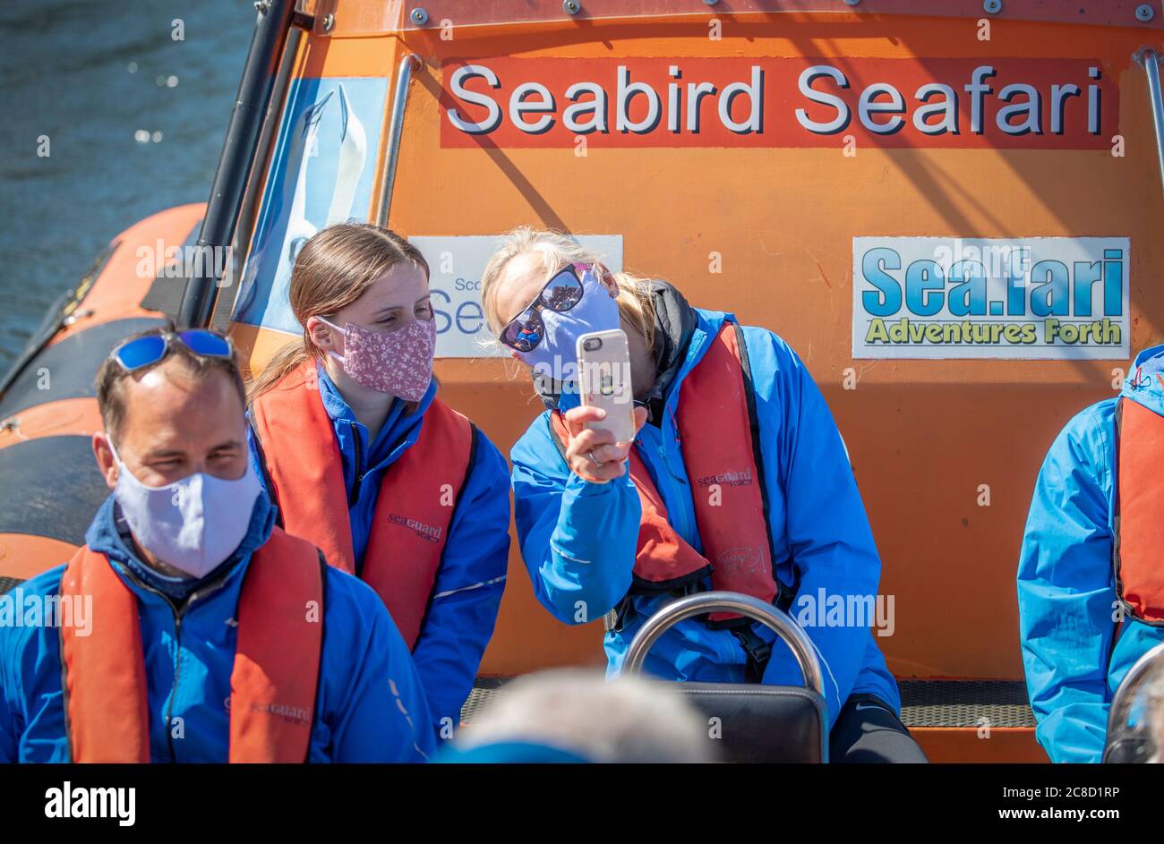 I membri del pubblico indossano rivestimenti protettivi sulla Seabird SEAFARI, una delle prime gite in barca dal Centro Scozzese Seabird a North Berwick, che ha riaperto oggi dopo essere stato chiuso per quattro mesi, mentre la Scozia continua con la graduale eliminazione delle restrizioni per facilitare l'uscita dalla chiusura. Foto Stock