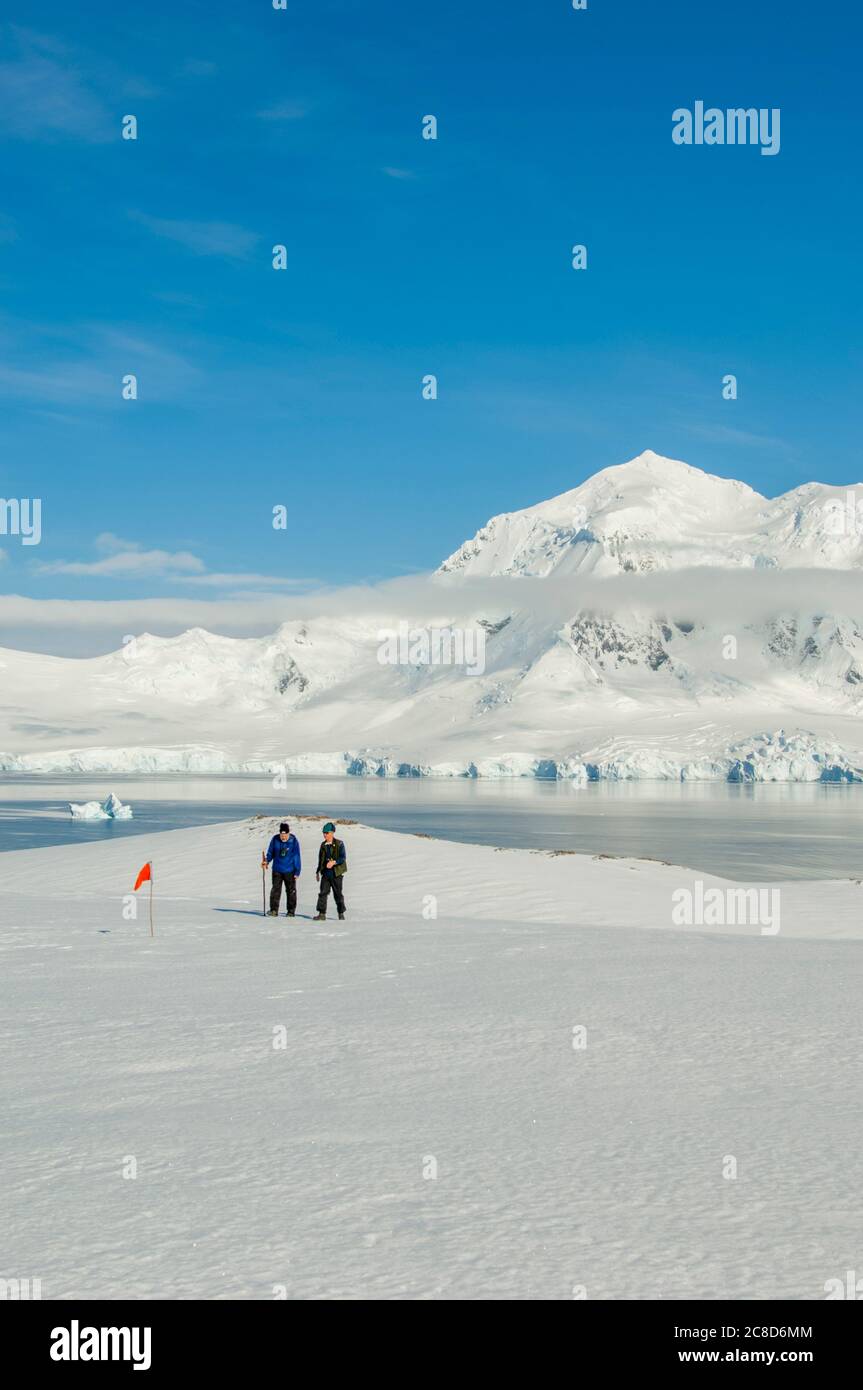 I turisti camminano sul ghiacciaio a Damoy Point, il punto di ingresso nord al porto di Port Lockroy, sul lato occidentale dell'isola di Wiencke in Th Foto Stock