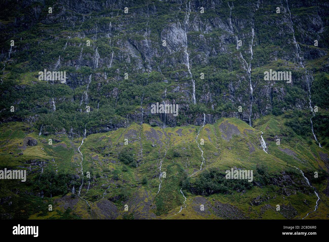 Il lussureggiante fronte di Green Cliff di una montagna Scozzese in The Glens con mini cascate Foto Stock