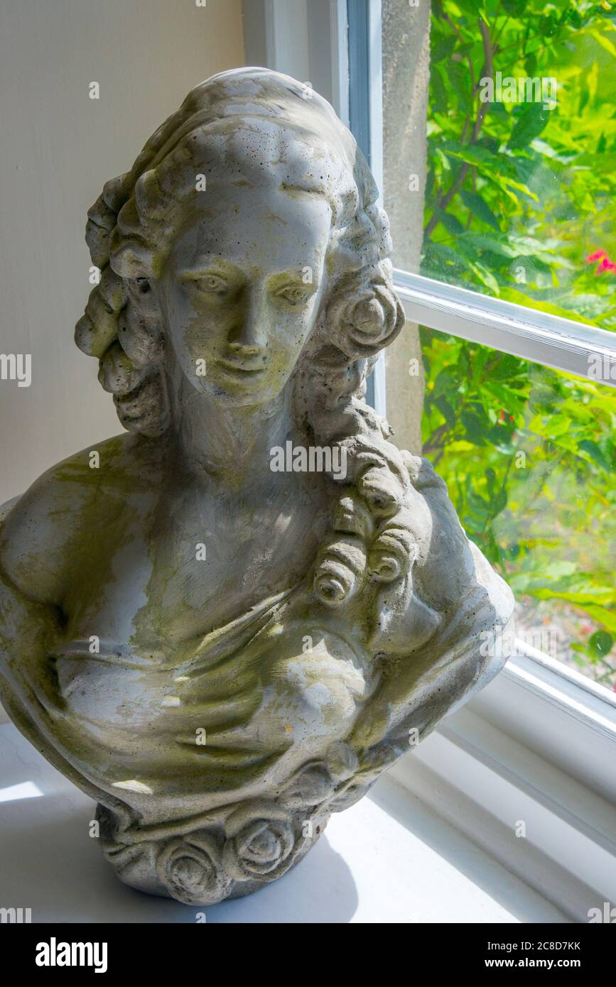 Giovane Donna, busto in stile 18 ° secolo, sul davanzale cottage Foto Stock