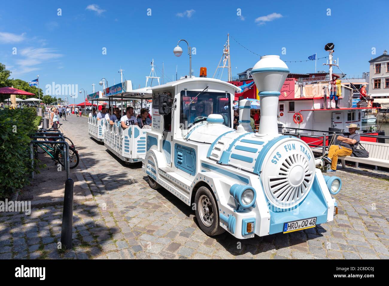 Treno senza binario per visite turistiche al canale chiamato ‘Alter Strom’ (canale Vecchio) nel quartiere Warnemünde della città di Rostock, Germania Foto Stock