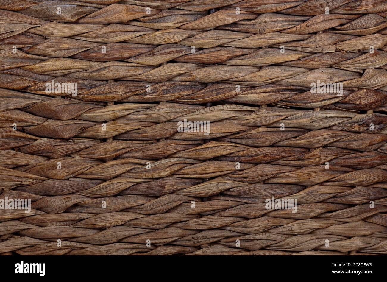 macro shot di una struttura di tessitura di un cestello in vimini piatto, rustico, in direzione orizzontale in colori marrone, terra per l'uso come sfondo o per la composizione Foto Stock