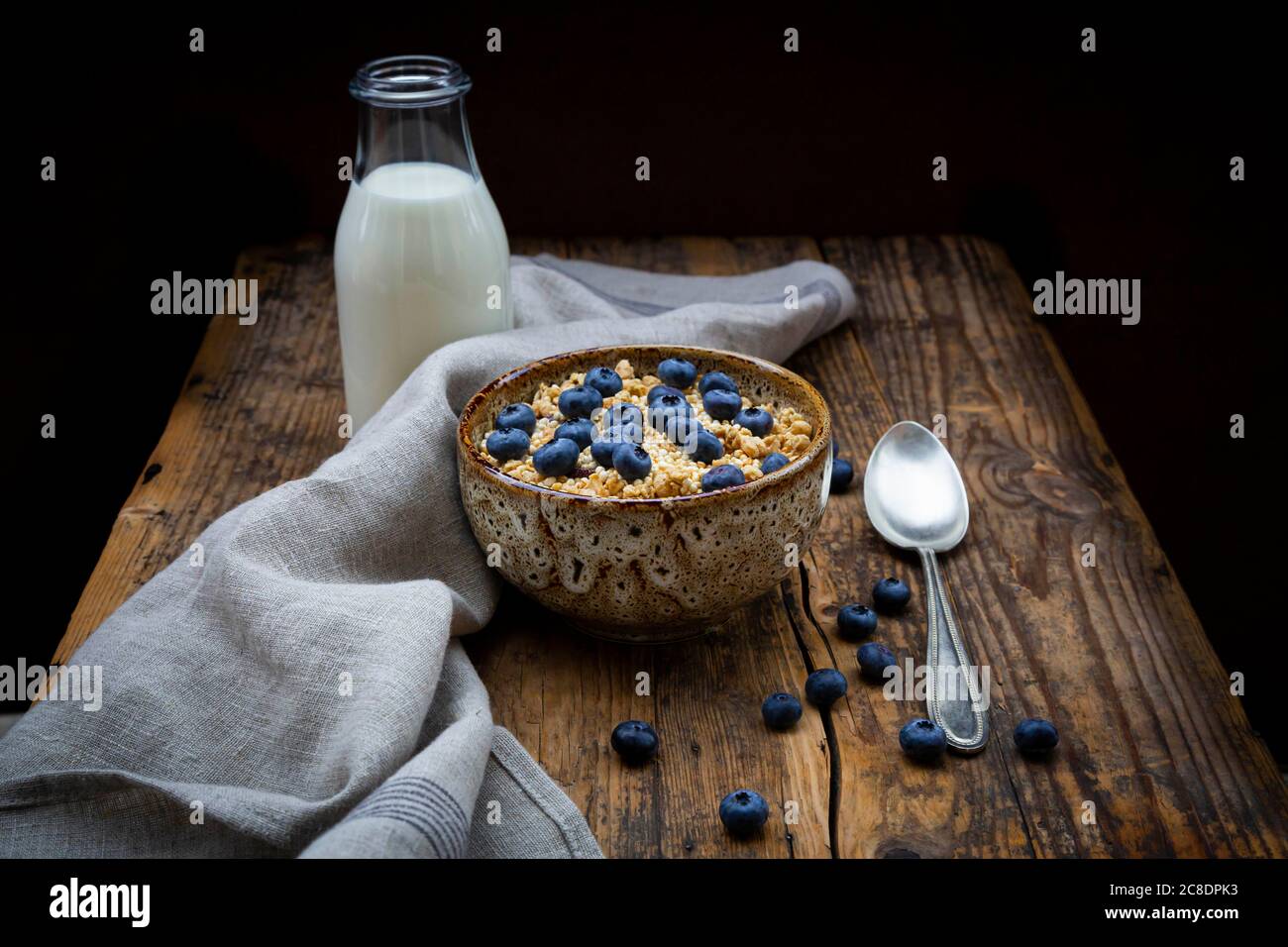 Bottiglia di latte e recipiente di granola con mirtilli e quinoa Foto Stock