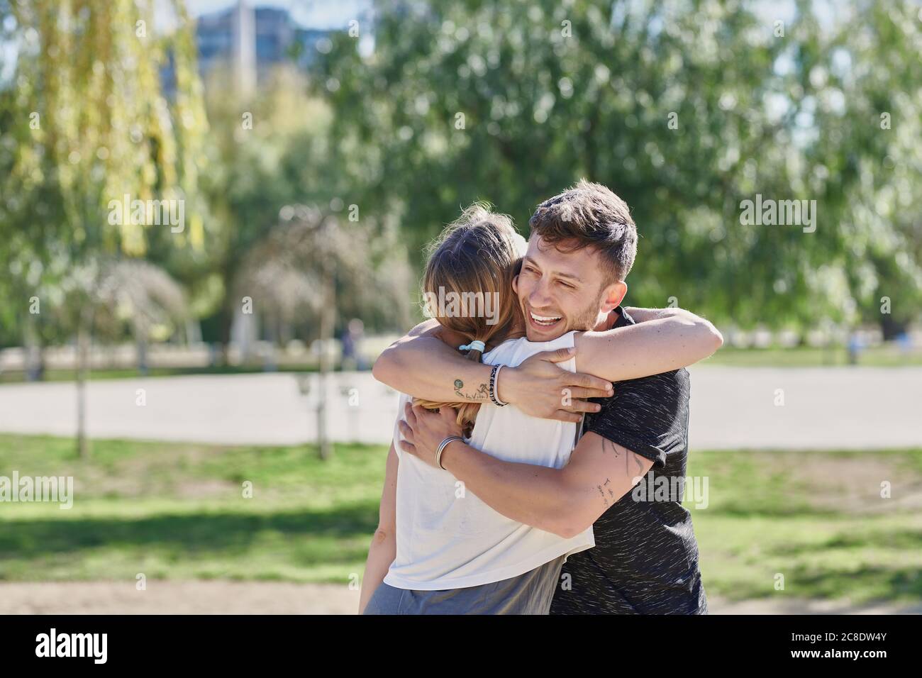 Abbracciare la coppia prima di allenarsi nel parco Foto Stock