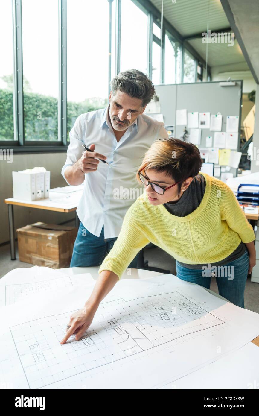 Maschio e femmina di architetti a discutere il piano di massa in office Foto Stock