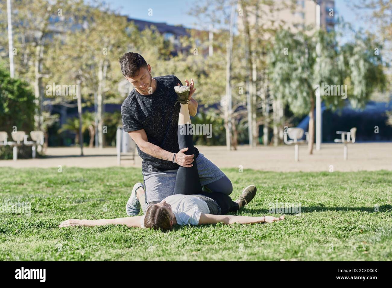 Donna durante il lavoro con allenatore nel parco Foto Stock