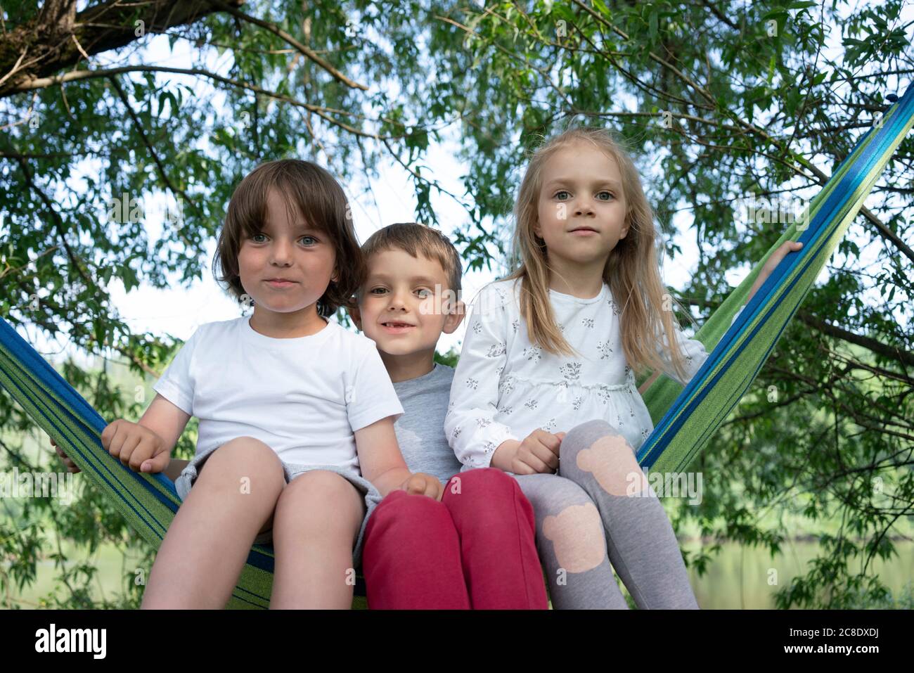 Carino bambini seduti su amaca in foresta Foto Stock