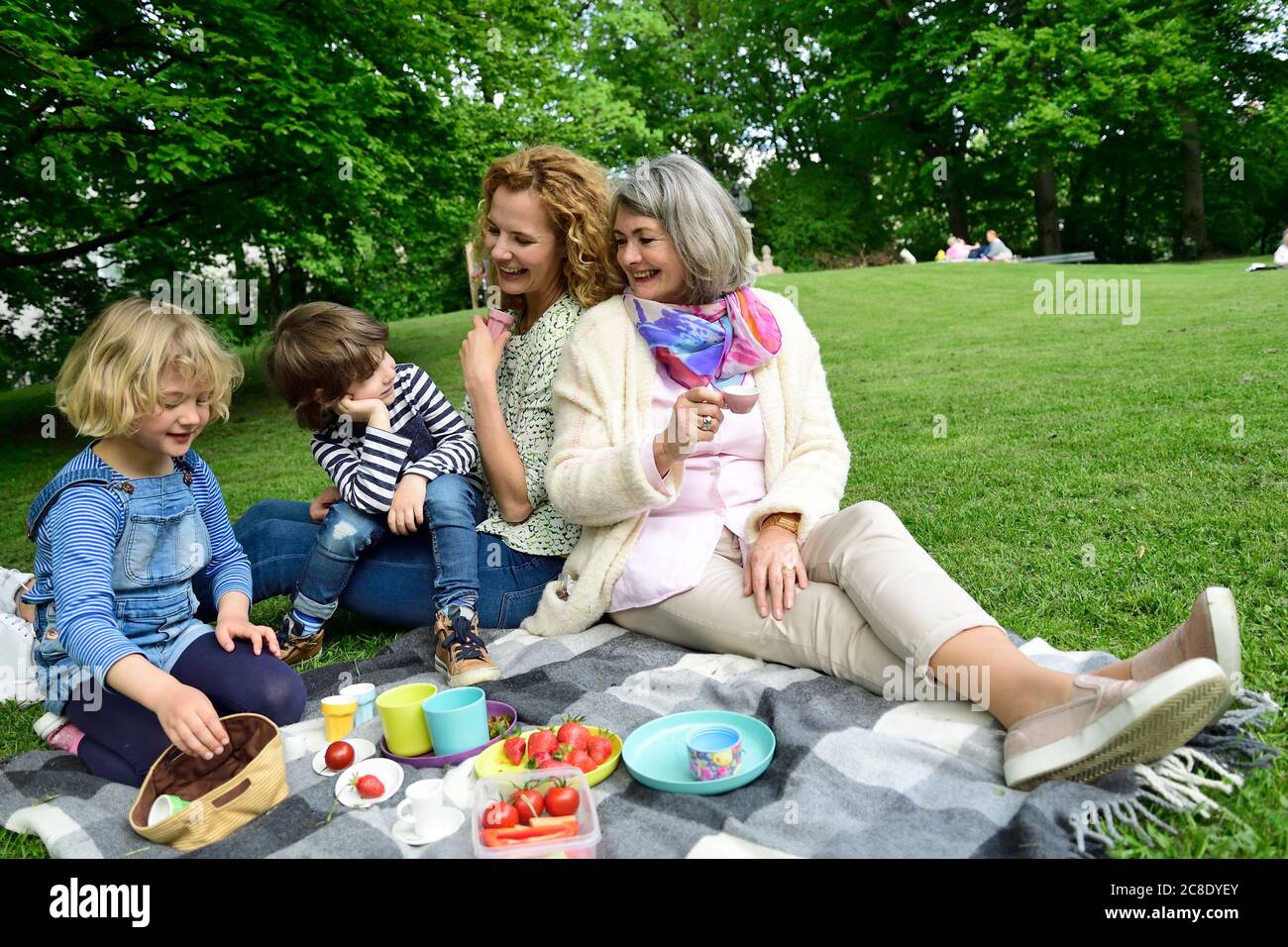 Felice famiglia di tre generazioni godendo pic-nic al parco pubblico Foto Stock