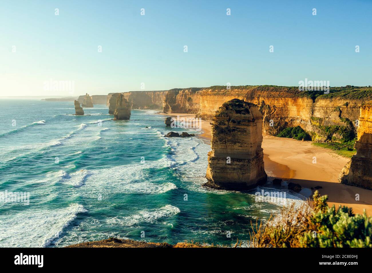 Vista panoramica dei dodici Apostoli contro il cielo limpido durante il tramonto, Great Ocean Road, Victoria, Australia Foto Stock