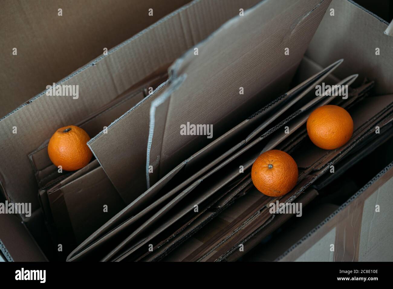Tre arance su scatole di cartone Foto Stock