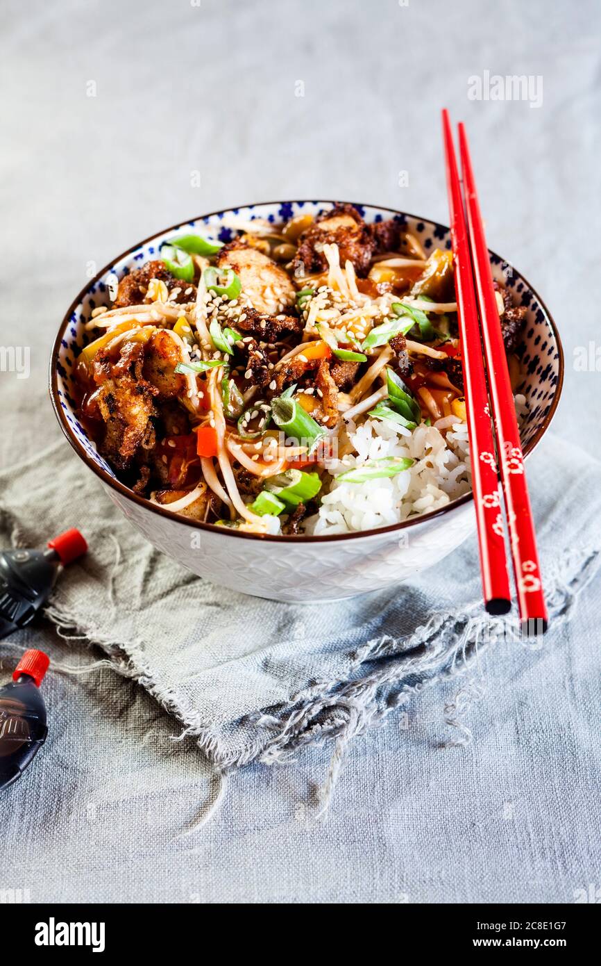 Ciotola con pollo dolce e agrodolce e verdure sul riso Foto Stock