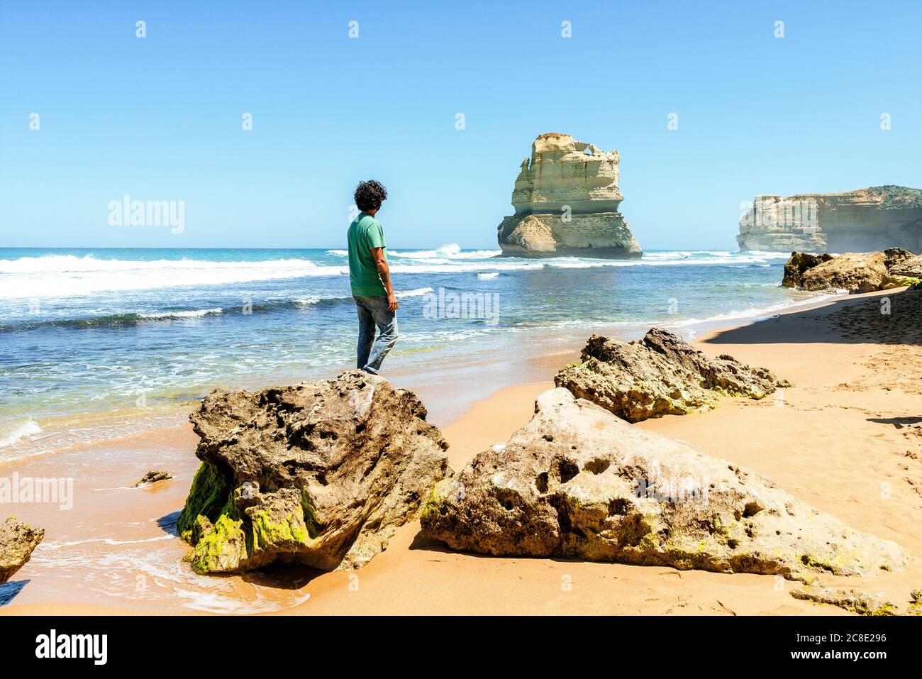 Uomo che guarda il mare contro il cielo limpido mentre si trova sulla roccia a Gibson Beach, Great Ocean Road, Australia Foto Stock