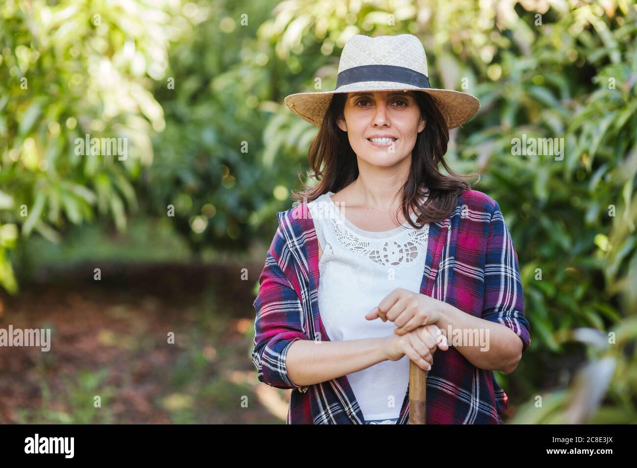 Donna giardiniere con zappa in giardino Foto Stock