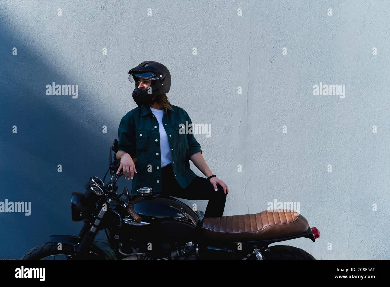 Donna che indossa il casco in piedi in moto Foto Stock