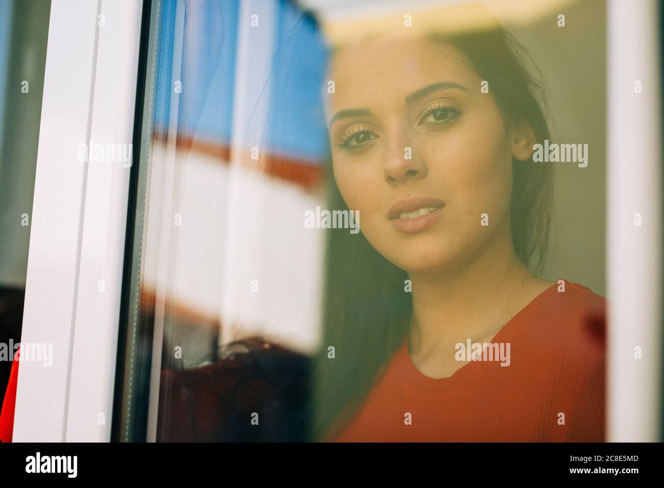 Primo piano di una giovane donna vista attraverso la porta di vetro Foto Stock